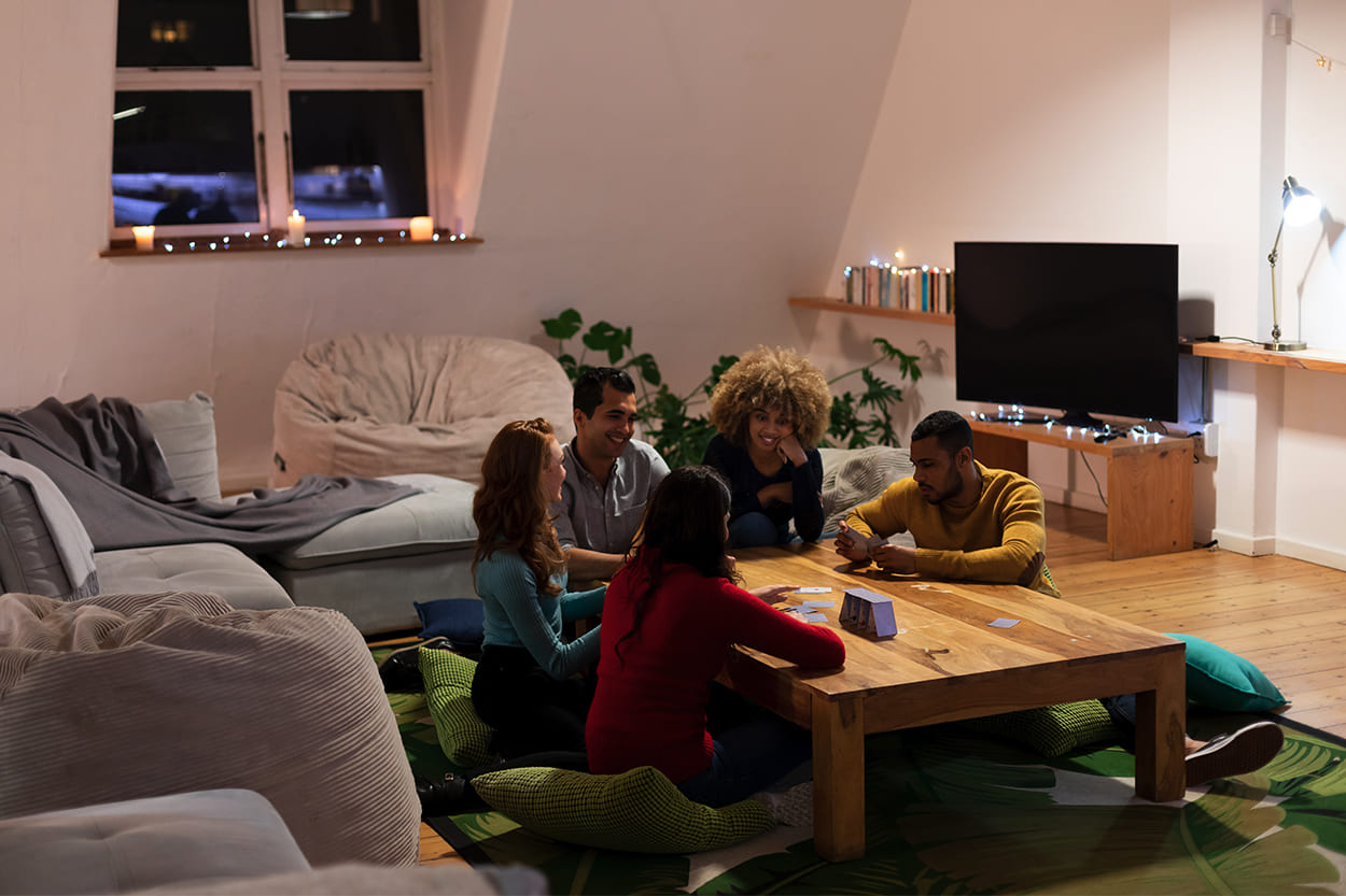 Photo of students playing cards together in share house living room