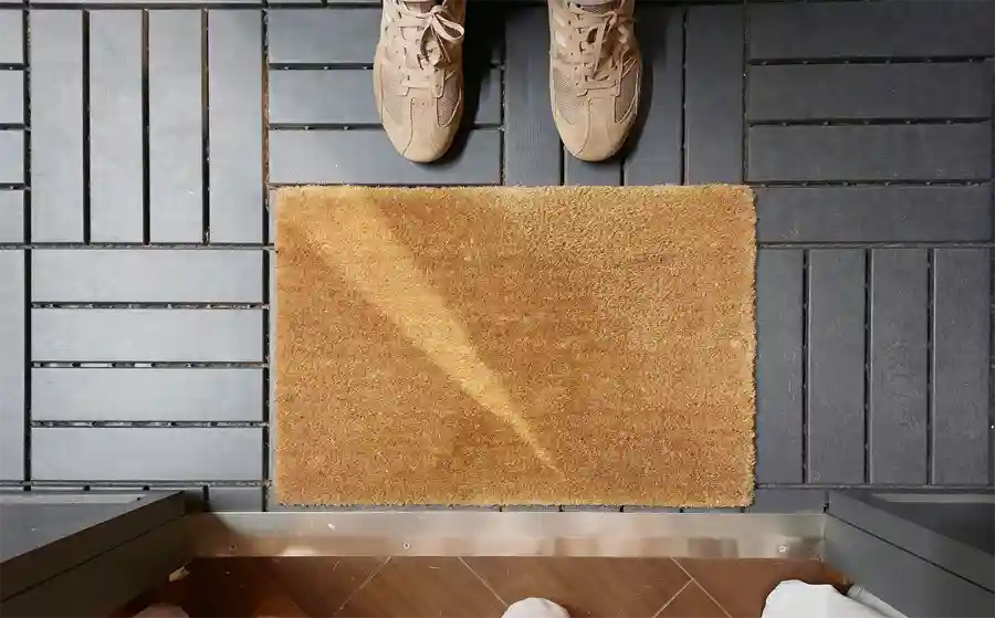 Someone standing in front of a door matt