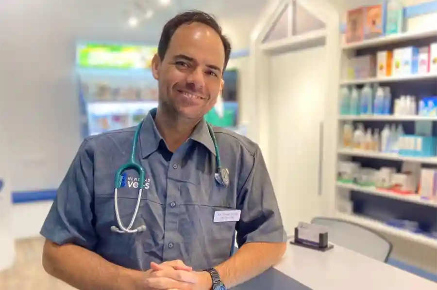 Photo of Dr Thiago leaning on a desk at a veterinary clinic