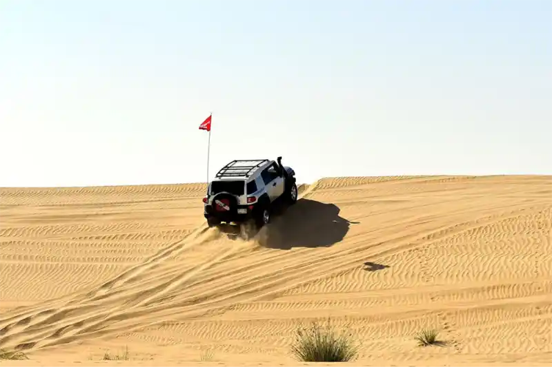 4WD driving towards the top of a sand dune