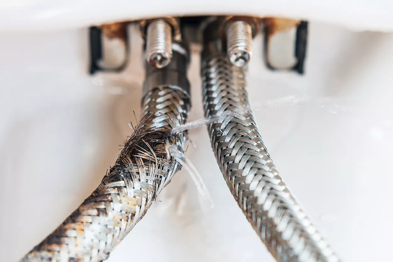 Close up photo of a frayed and leaking flexi-hose.