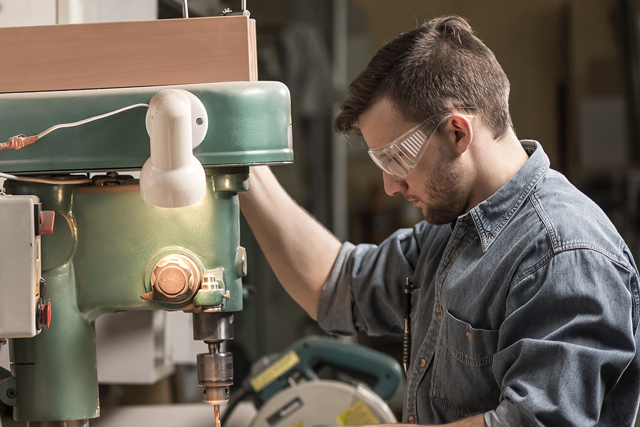 Carpenter concentrates while using a power tool to cut wood